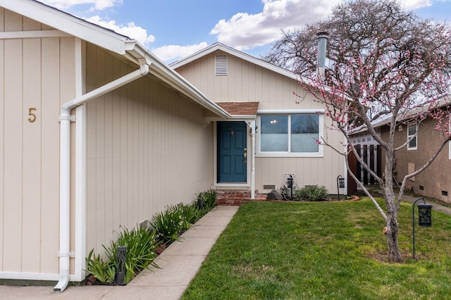 entrance to property with a lawn