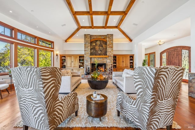 living area featuring high vaulted ceiling, a fireplace, and wood finished floors