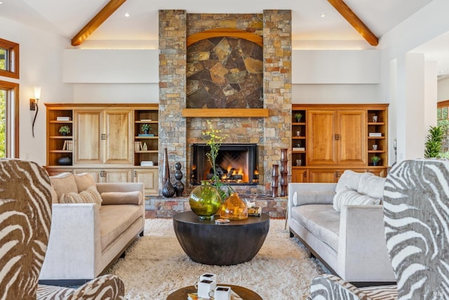 living room with a towering ceiling, a fireplace, and beamed ceiling