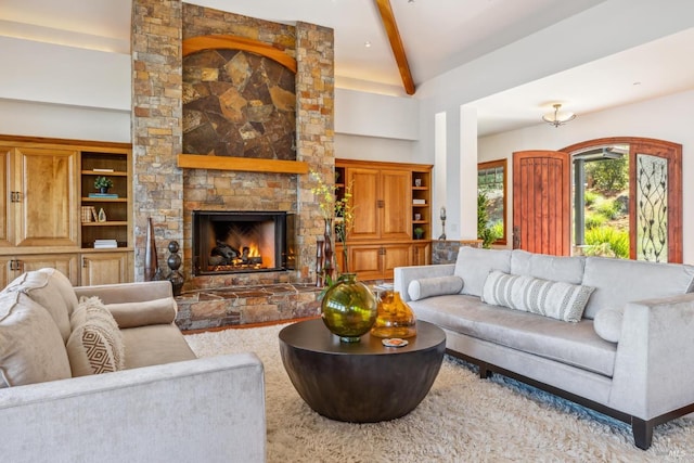 living area with high vaulted ceiling, a fireplace, and beam ceiling