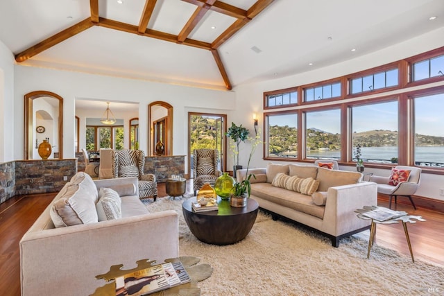 living area featuring high vaulted ceiling, beamed ceiling, a water view, and wood finished floors