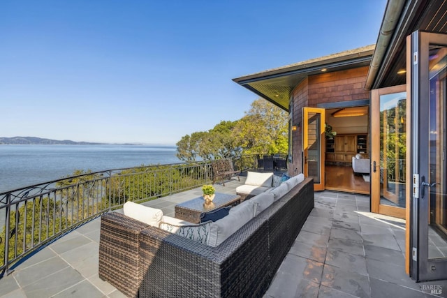 view of patio with outdoor lounge area and a water view