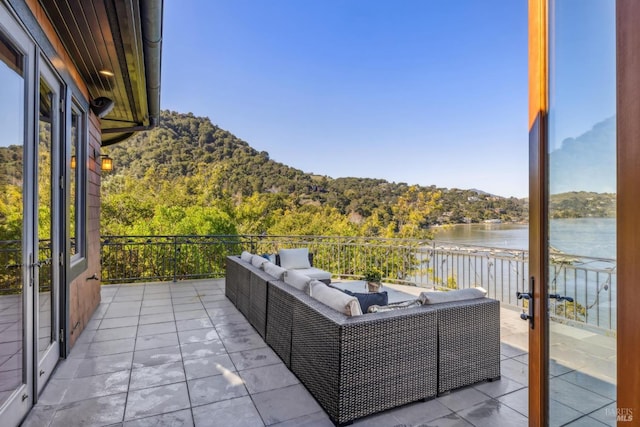 view of patio / terrace with outdoor lounge area, a water view, and a balcony