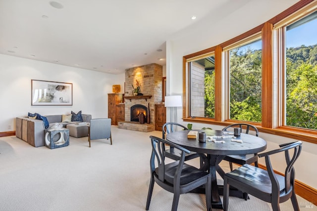 carpeted dining room featuring recessed lighting, baseboards, and a stone fireplace