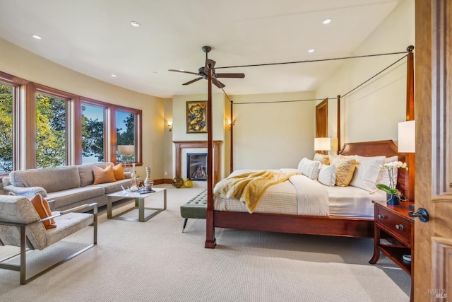 bedroom featuring carpet, recessed lighting, baseboards, and a glass covered fireplace