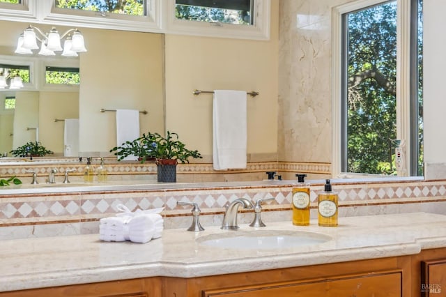 bathroom with tasteful backsplash, a wealth of natural light, and vanity