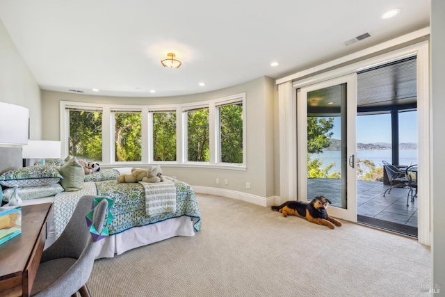 bedroom featuring visible vents, a water view, access to exterior, carpet floors, and multiple windows