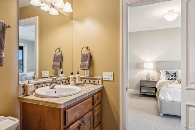 bathroom with baseboards, connected bathroom, and vanity