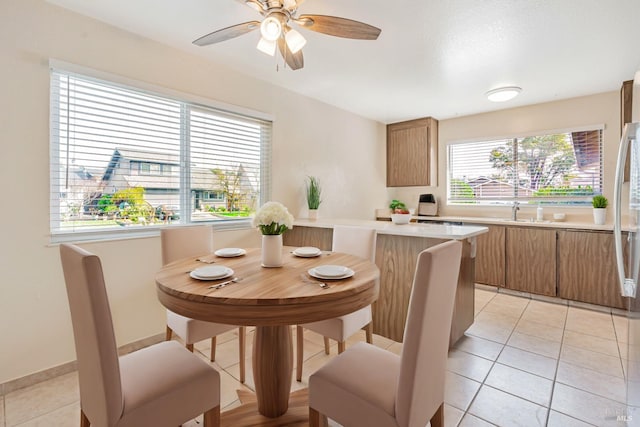 kitchen featuring a peninsula, brown cabinetry, light countertops, and light tile patterned flooring