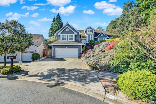 traditional-style home featuring a garage, driveway, and stairway