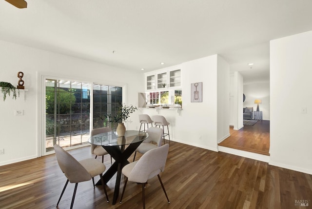 dining space featuring baseboards, wood finished floors, and recessed lighting