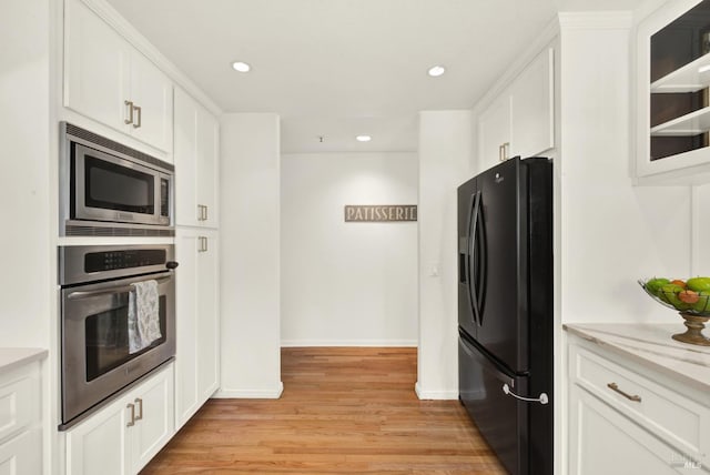 kitchen featuring light wood finished floors, white cabinets, glass insert cabinets, stainless steel appliances, and recessed lighting