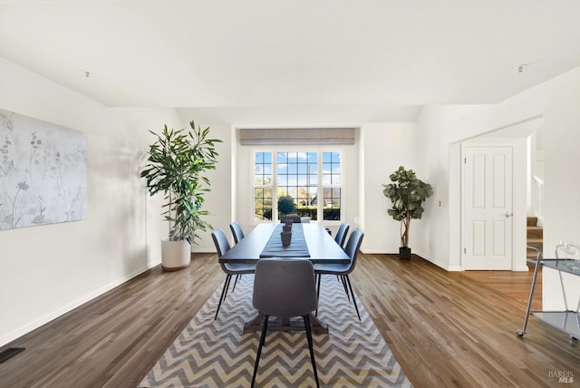 dining room featuring dark wood-style floors, stairway, and baseboards