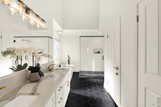 bathroom featuring double vanity, a towering ceiling, a sink, a shower stall, and tile patterned flooring