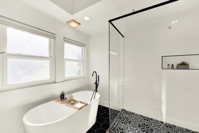 bathroom with recessed lighting, a soaking tub, a tile shower, and baseboards