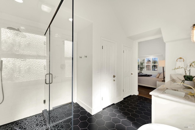 ensuite bathroom featuring lofted ceiling, tile patterned flooring, vanity, a stall shower, and ensuite bath