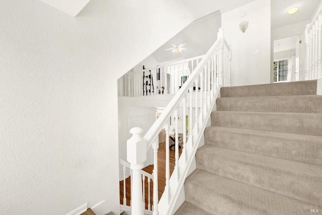 stairway with lofted ceiling, baseboards, and wood finished floors