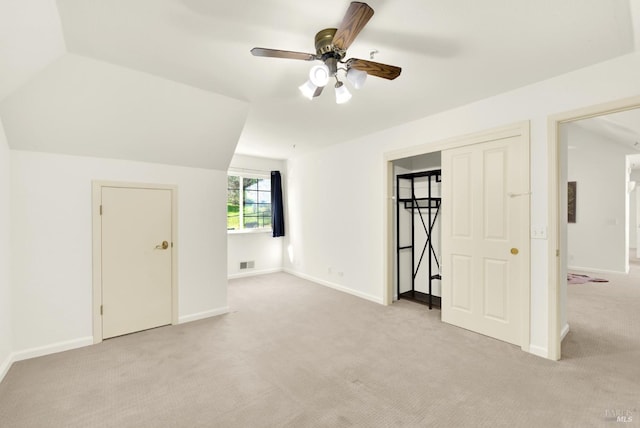 additional living space featuring lofted ceiling, baseboards, visible vents, and light colored carpet