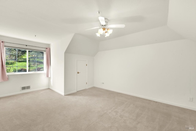 bonus room with light carpet, a ceiling fan, visible vents, vaulted ceiling, and baseboards