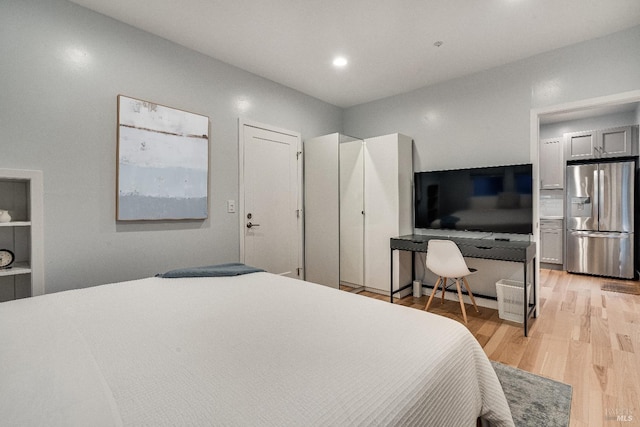 bedroom featuring light wood finished floors, stainless steel refrigerator with ice dispenser, and recessed lighting