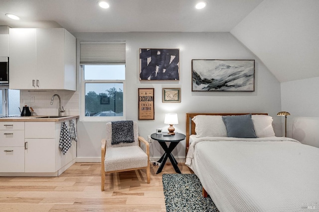 bedroom featuring light wood-type flooring, a sink, baseboards, and recessed lighting