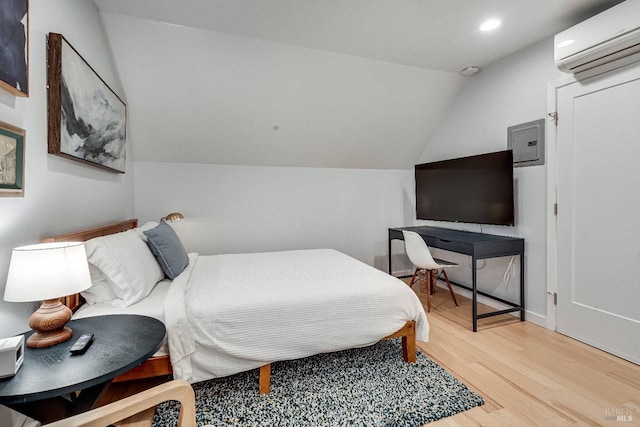 bedroom with vaulted ceiling, an AC wall unit, wood finished floors, and recessed lighting