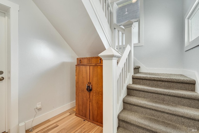 stairway featuring baseboards and wood finished floors