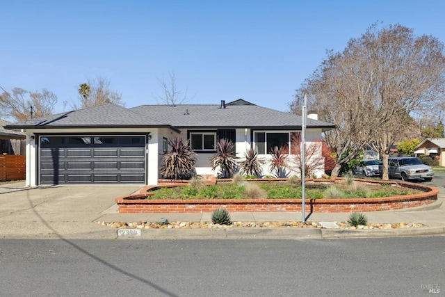 ranch-style home featuring a garage and concrete driveway