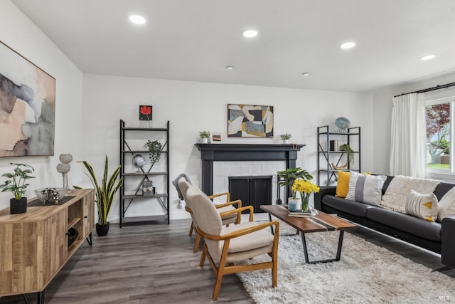 living room with recessed lighting, a fireplace, baseboards, and wood finished floors