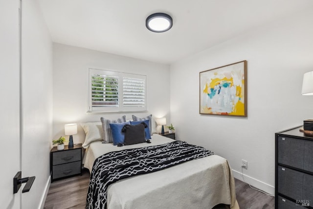 bedroom with wood finished floors and baseboards