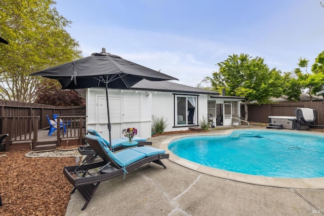 view of pool with a fenced in pool, a patio area, a fenced backyard, and a wooden deck