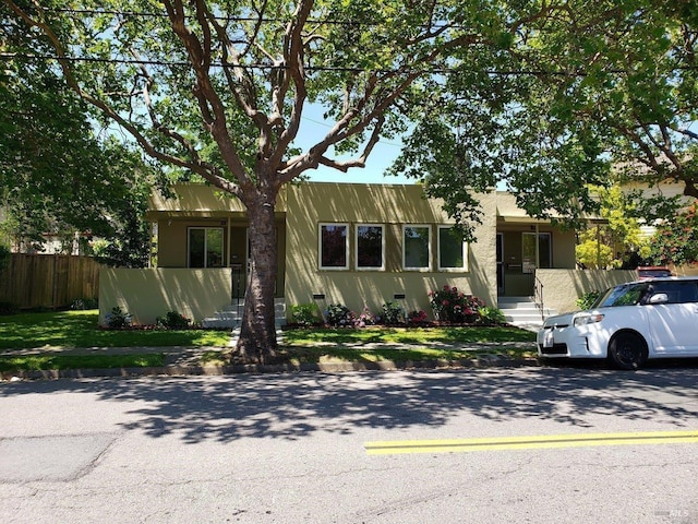 view of front of house featuring fence and stucco siding