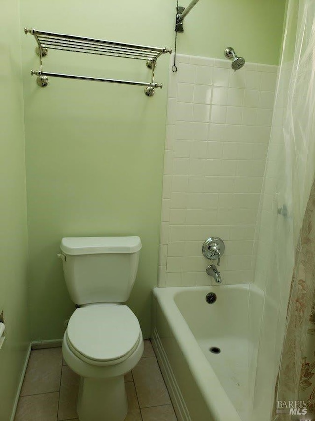 bathroom featuring baseboards, shower / tub combo, toilet, and tile patterned floors