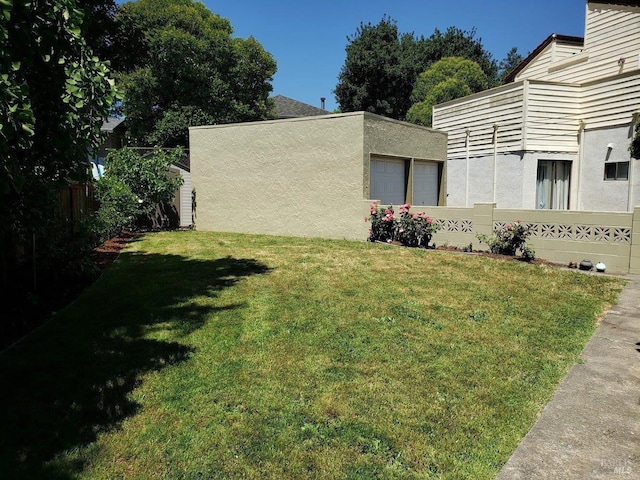 view of yard with fence and an outdoor structure