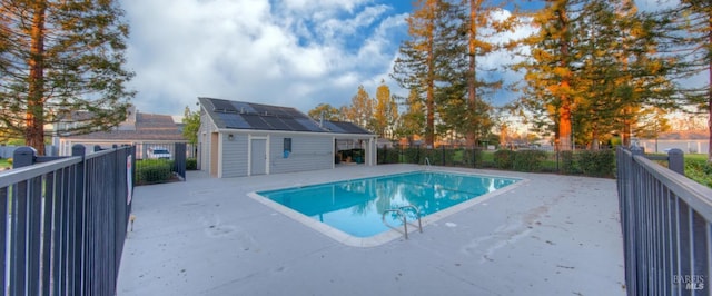 view of pool with a fenced in pool, an outbuilding, a patio area, and a fenced backyard