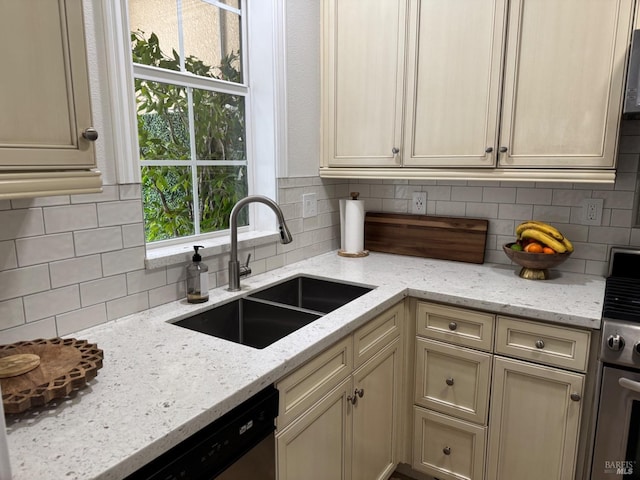 kitchen with light stone countertops, stainless steel appliances, decorative backsplash, and a sink