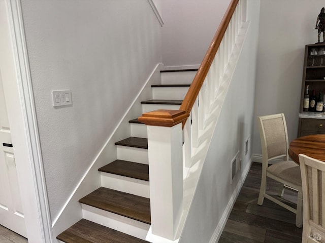 stairs featuring wood finished floors and visible vents