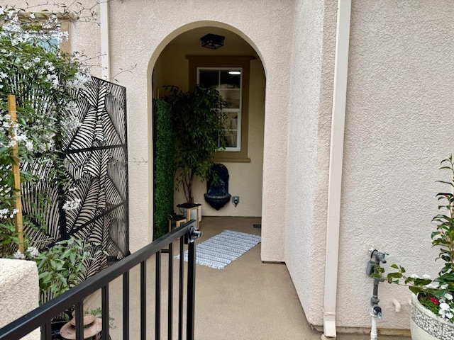 entrance to property with a balcony and stucco siding