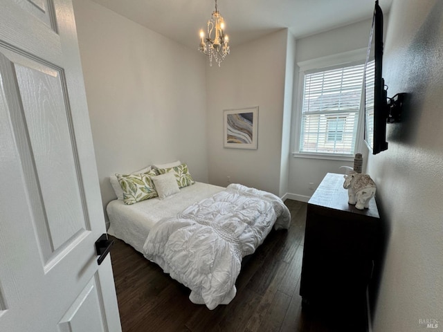 bedroom with baseboards, dark wood finished floors, and an inviting chandelier