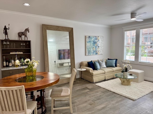 living area with recessed lighting, ornamental molding, a ceiling fan, light wood-type flooring, and baseboards