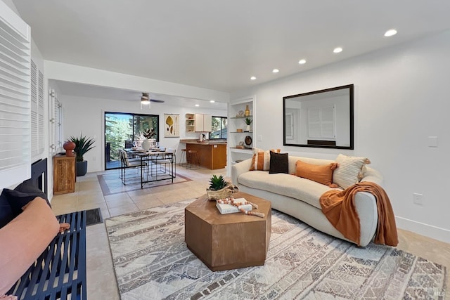 living room featuring recessed lighting, a fireplace, baseboards, and light tile patterned floors