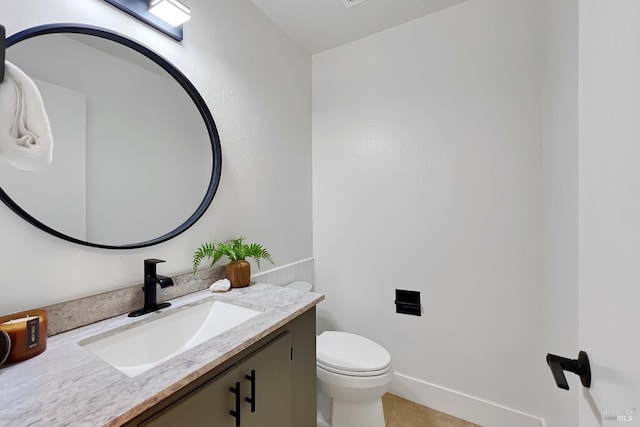 half bathroom with vanity and toilet