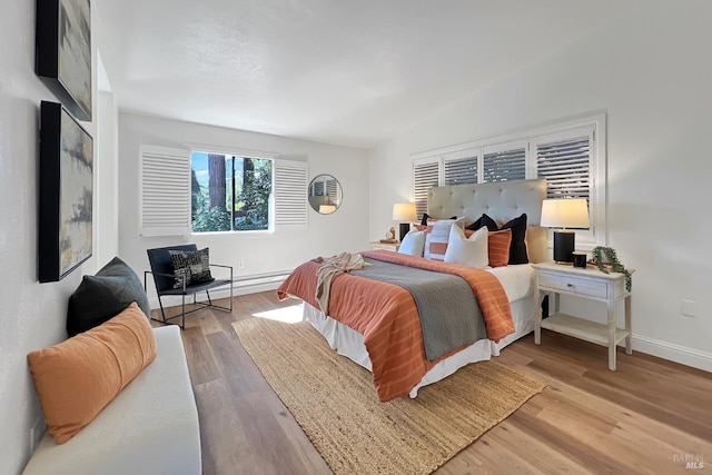 bedroom with baseboards, vaulted ceiling, and wood finished floors