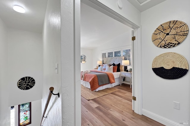 bedroom with baseboards and light wood finished floors