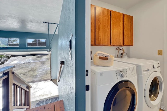 laundry area featuring washing machine and clothes dryer and cabinet space