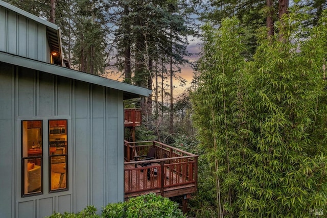 exterior space with board and batten siding and a deck