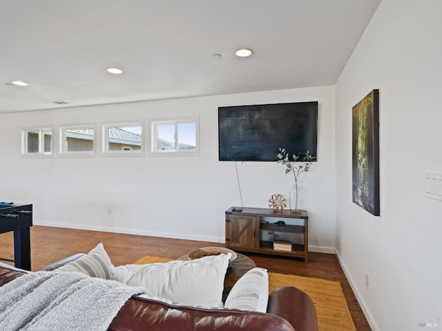 living area featuring baseboards, wood finished floors, and recessed lighting