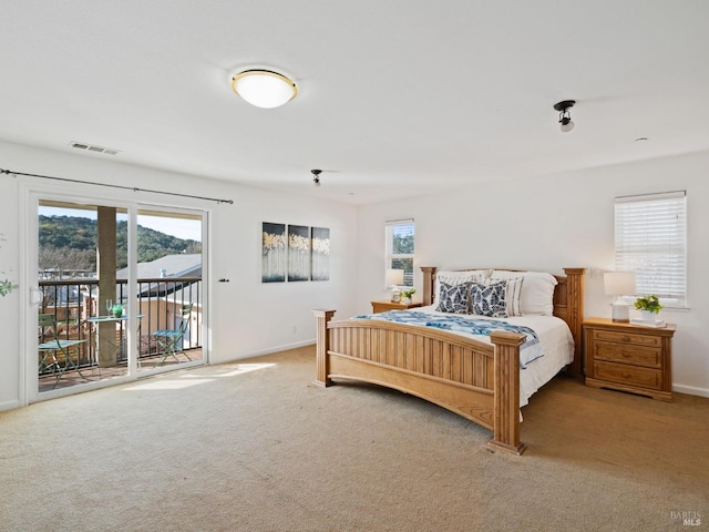 bedroom featuring access to outside, visible vents, carpet, and multiple windows