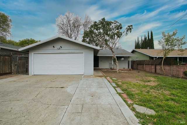 ranch-style house with a garage, fence, and driveway