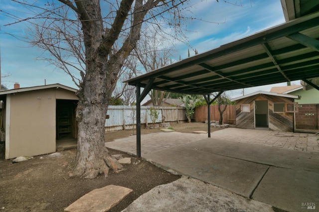 view of patio with an outbuilding and fence